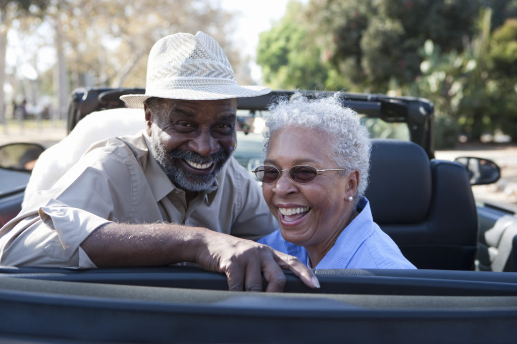 Portrait of senior couple at the back seat of car, smiling
