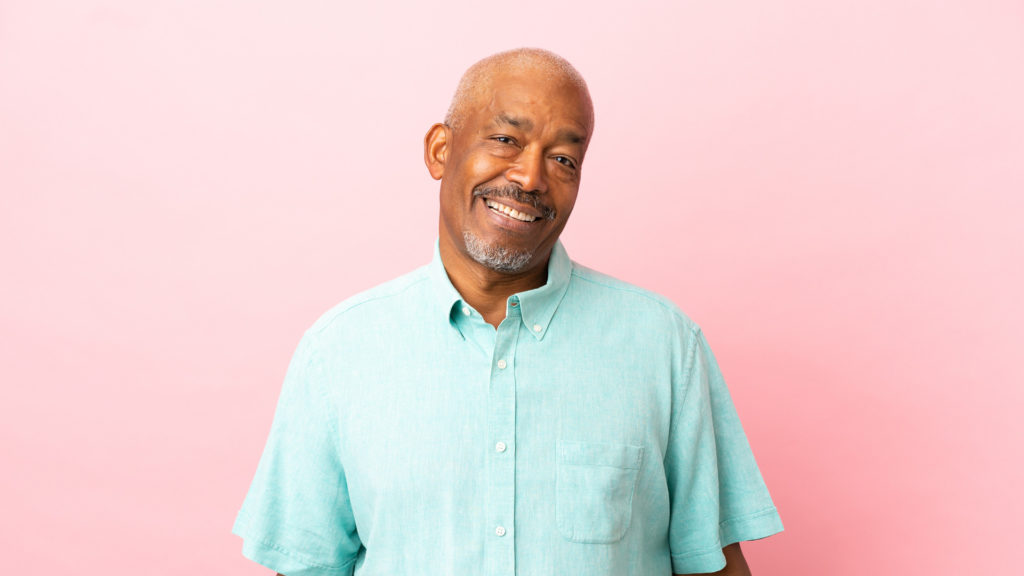 Cuban senior man isolated on pink background thinking about Enrolling in Medicare.