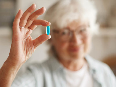 Older woman holding pill