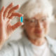 Older woman holding pill