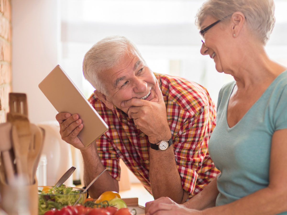 Senior couple smiling and talking about choosing between Medigap plans.