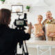 Director filming seniors holding grocery bags in their kitchen as they discuss the truth about Medicare commercials.