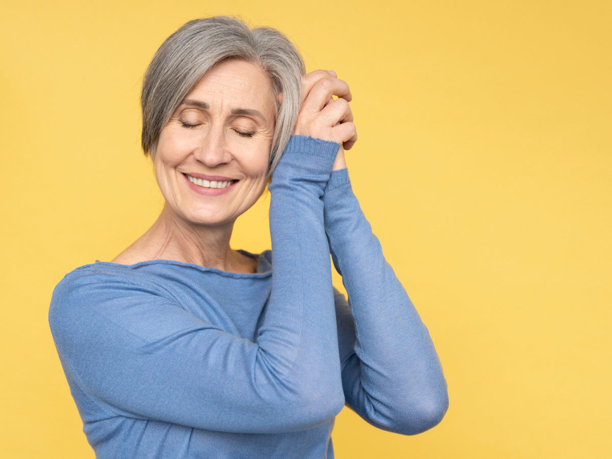 Woman smiling with her eyes closed and hands clasped asking herself What is the Medicare Open Enrollment Period (OEP)?